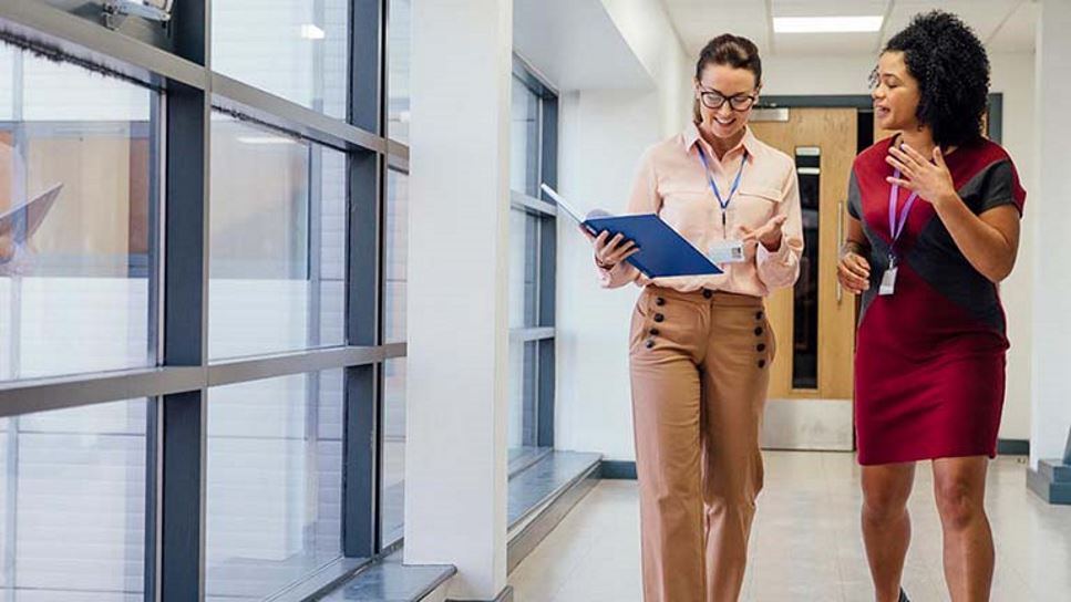 educator and student walking down hall together