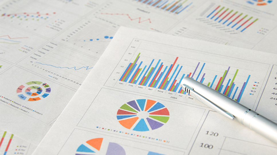 printed pages of charts and research laying on a table